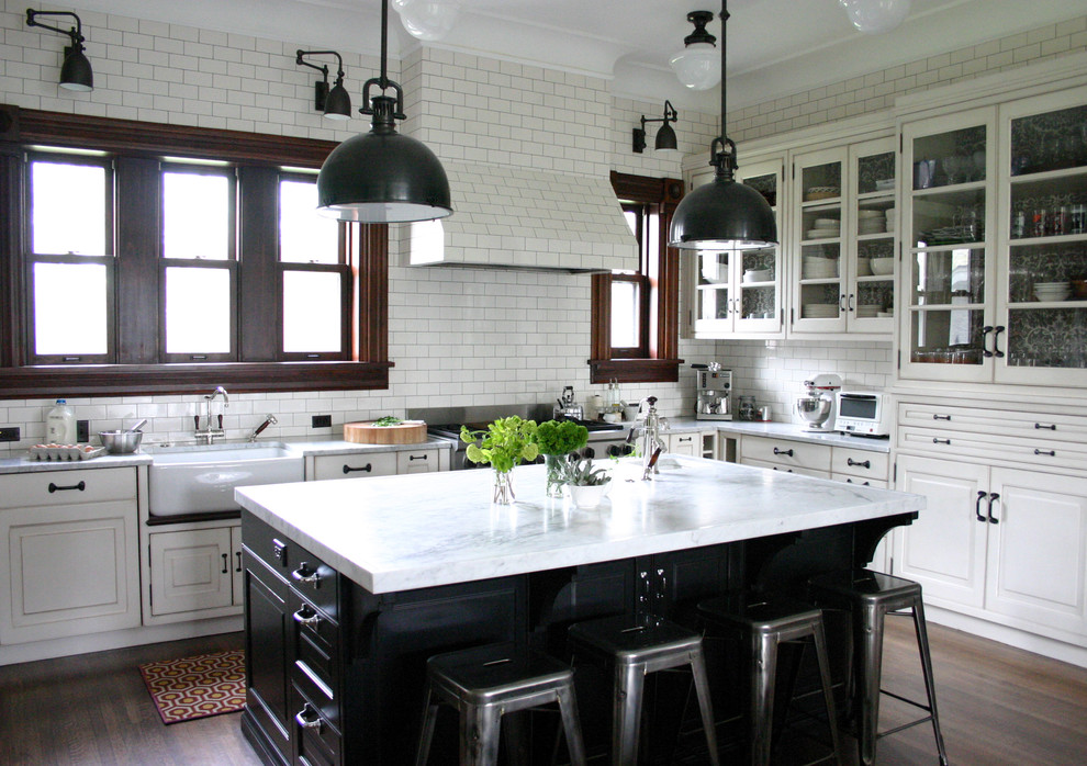 Kitchen - traditional kitchen idea in Chicago with glass-front cabinets, stainless steel appliances, a farmhouse sink, marble countertops, white backsplash, subway tile backsplash and white countertops