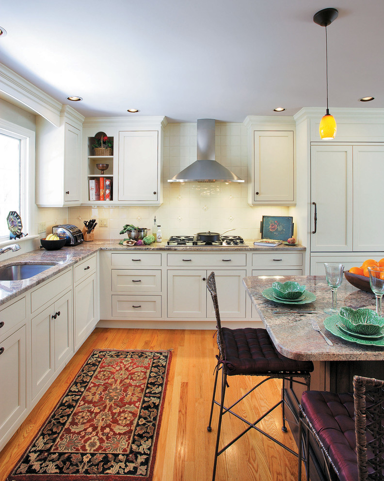 Klassische Küche in L-Form mit Schrankfronten im Shaker-Stil, weißen Schränken, Küchenrückwand in Weiß und Elektrogeräten mit Frontblende in Sonstige