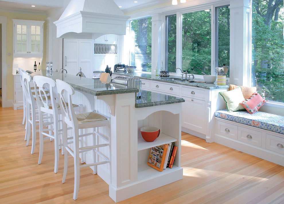 他の地域にあるトラディショナルスタイルのおしゃれなキッチン (パネルと同色の調理設備、白いキャビネット、緑のキッチンカウンター) の写真