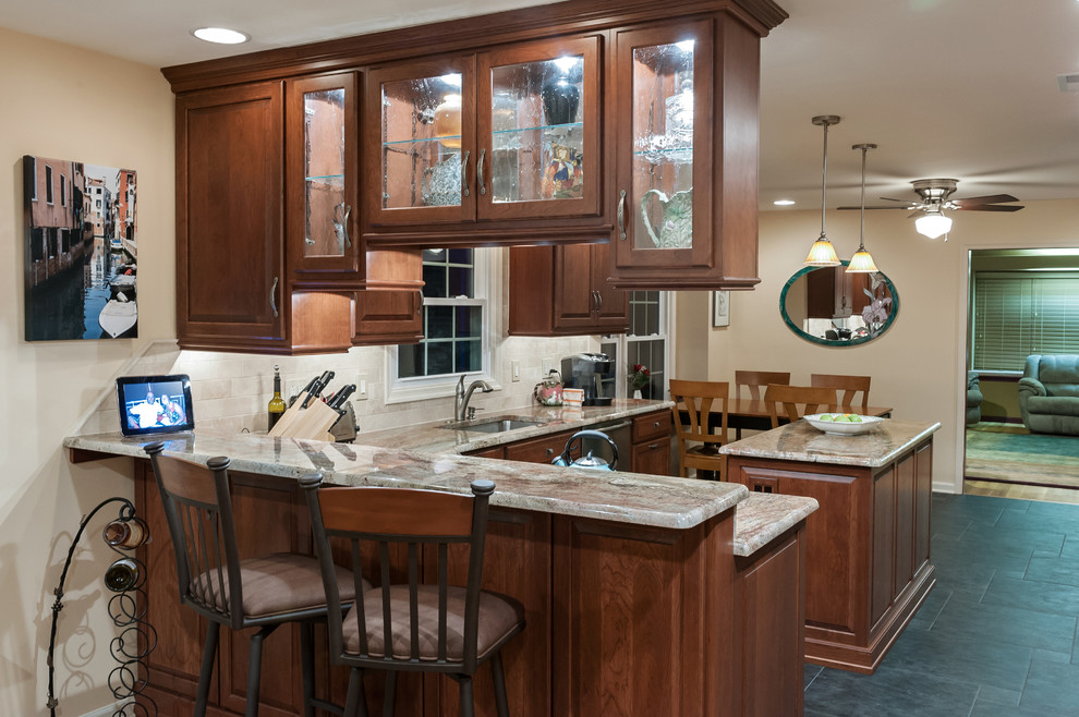 Elegant u-shaped porcelain tile eat-in kitchen photo in Philadelphia with an undermount sink, raised-panel cabinets, medium tone wood cabinets, granite countertops, stainless steel appliances and an island
