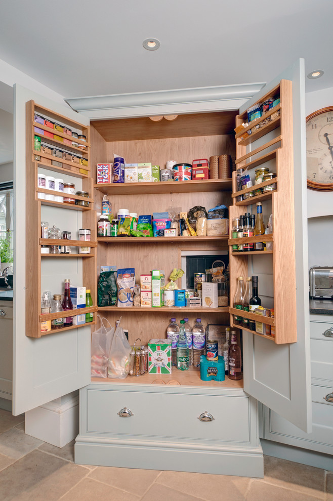 Design ideas for a large traditional galley kitchen pantry in Other with a belfast sink, flat-panel cabinets, blue cabinets, granite worktops, black appliances, limestone flooring and an island.
