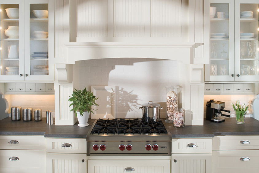 Example of a classic single-wall eat-in kitchen design in Philadelphia with a farmhouse sink, recessed-panel cabinets, white cabinets, soapstone countertops, white backsplash, subway tile backsplash and stainless steel appliances