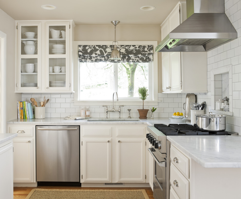 シアトルにあるトラディショナルスタイルのおしゃれなキッチン (ガラス扉のキャビネット、シルバーの調理設備) の写真