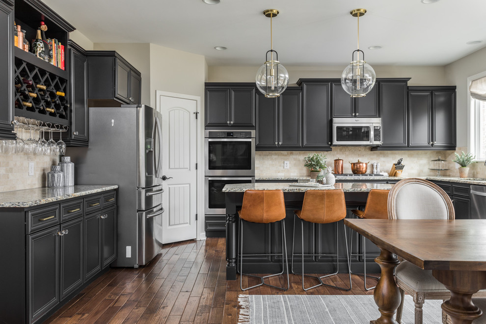 Classic u-shaped kitchen/diner in Indianapolis with recessed-panel cabinets, grey cabinets, beige splashback, stainless steel appliances, medium hardwood flooring, an island and brown floors.