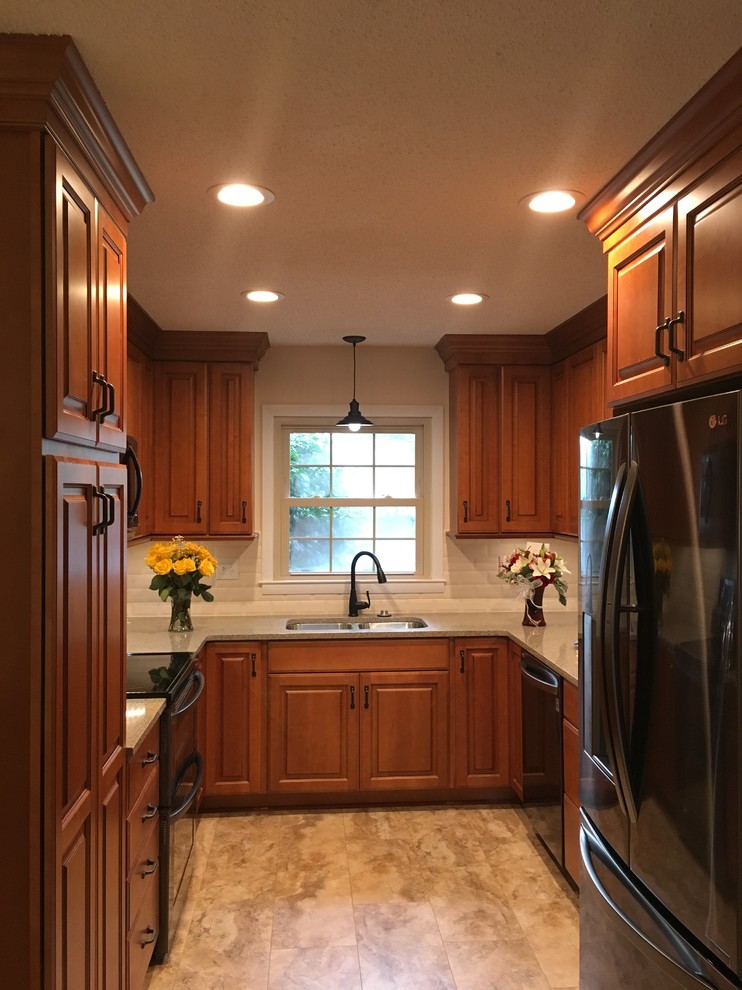 Exempel på ett litet klassiskt kök, med en undermonterad diskho, luckor med upphöjd panel, bruna skåp, bänkskiva i kvartsit, gult stänkskydd, stänkskydd i porslinskakel, rostfria vitvaror, vinylgolv och beiget golv