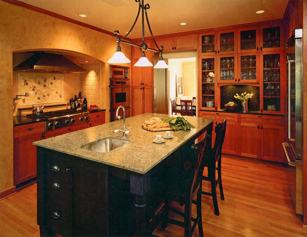 Стильный дизайн: п-образная кухня в классическом стиле с врезной мойкой, фасадами цвета дерева среднего тона и барной стойкой - последний тренд