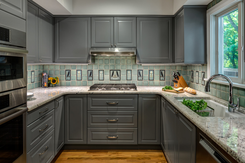 Idéer för att renovera ett mellanstort vintage u-kök, med en undermonterad diskho, luckor med upphöjd panel, grå skåp, blått stänkskydd, rostfria vitvaror, mellanmörkt trägolv, granitbänkskiva och stänkskydd i keramik