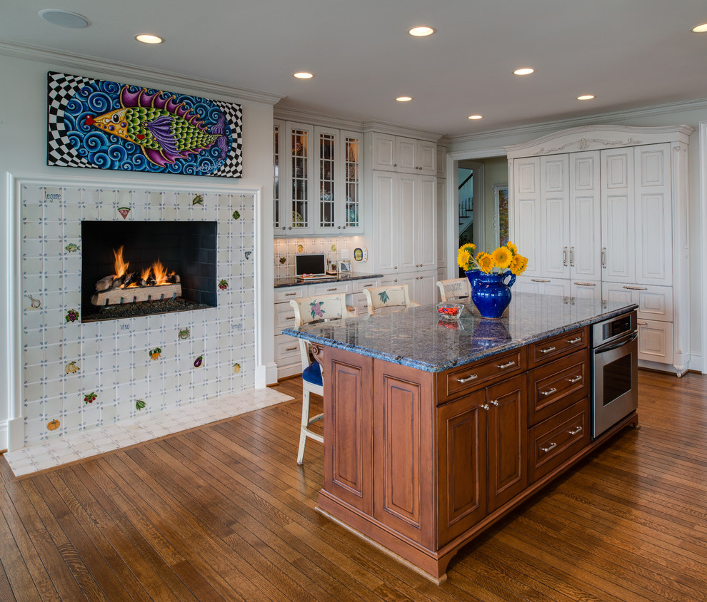 Immagine di un cucina con isola centrale tradizionale chiuso con paraspruzzi multicolore e pavimento in legno massello medio