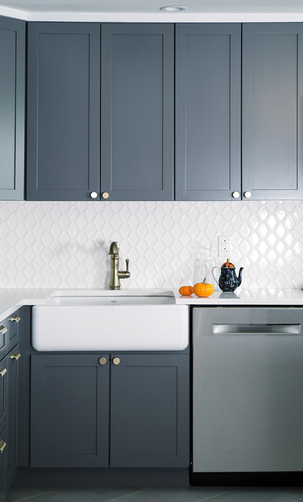 Example of a mid-sized classic l-shaped porcelain tile eat-in kitchen design in New York with a farmhouse sink, raised-panel cabinets, dark wood cabinets, quartz countertops, white backsplash, subway tile backsplash, stainless steel appliances and an island
