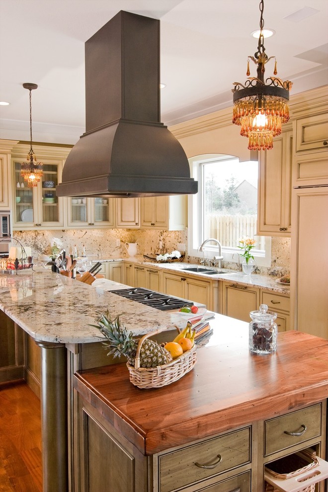Inspiration for a timeless galley kitchen remodel in Other with beaded inset cabinets, granite countertops, a double-bowl sink, beige cabinets, beige backsplash, stone slab backsplash and paneled appliances
