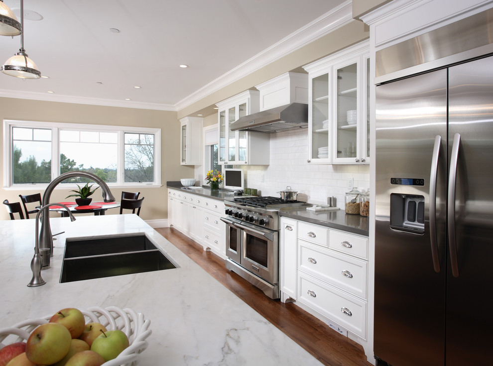 Example of a classic kitchen design in San Francisco with glass-front cabinets and stainless steel appliances