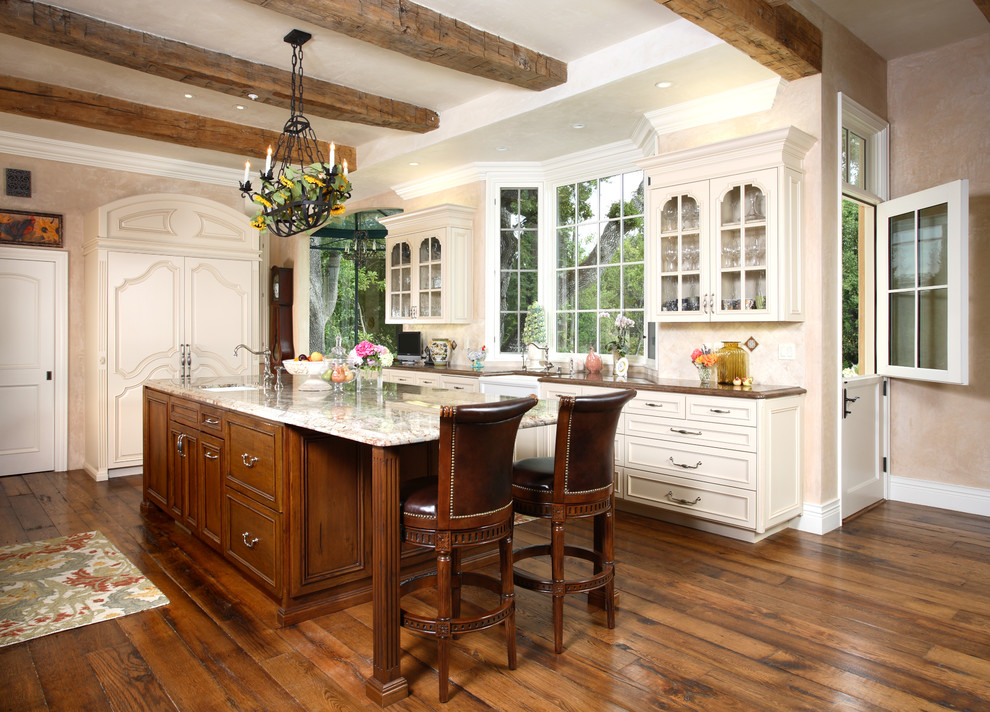 Example of a classic kitchen design in San Francisco with a farmhouse sink, glass-front cabinets, white cabinets and paneled appliances