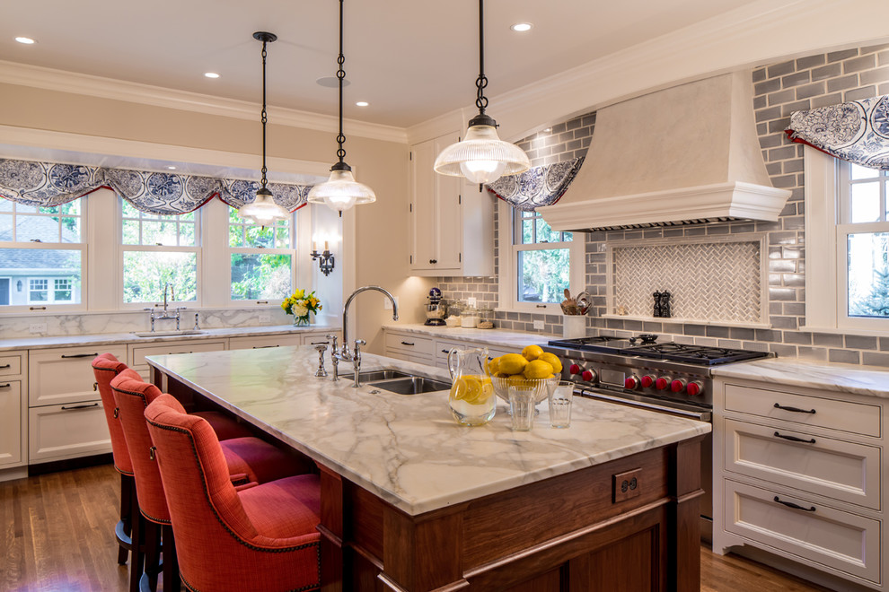 Example of a classic kitchen design in Minneapolis with a double-bowl sink, recessed-panel cabinets, beige cabinets, gray backsplash, subway tile backsplash and stainless steel appliances
