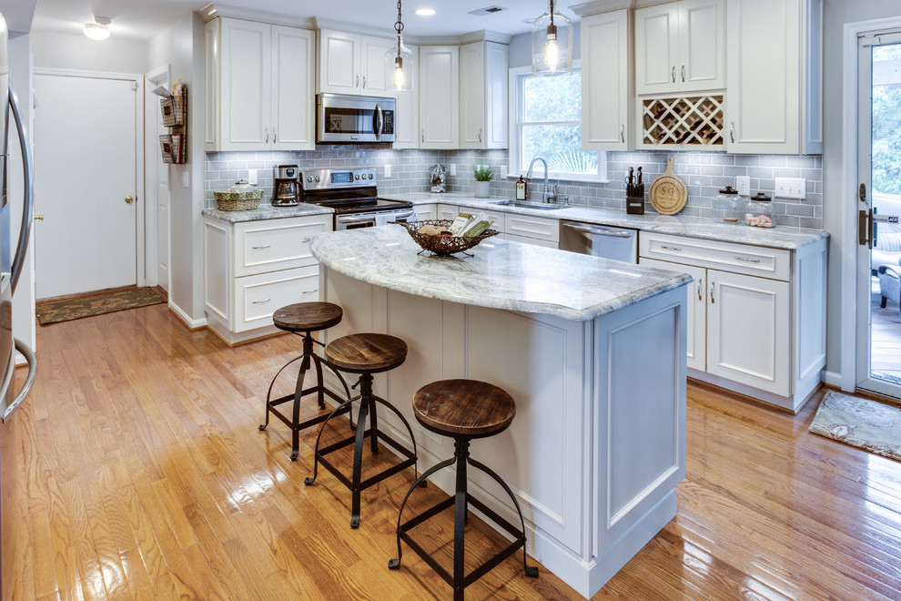 Photo of a medium sized traditional u-shaped kitchen in DC Metro with a submerged sink, granite worktops, grey splashback, stainless steel appliances, medium hardwood flooring and an island.