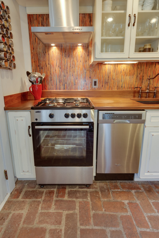 Imagen de cocina comedor clásica con armarios con paneles con relieve, puertas de armario blancas y encimera de madera