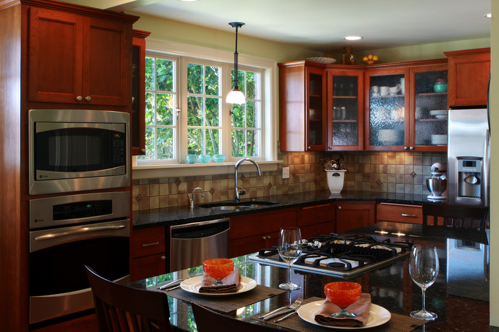 Small classic kitchen in Seattle with a submerged sink, shaker cabinets, medium wood cabinets, beige splashback, stainless steel appliances and an island.