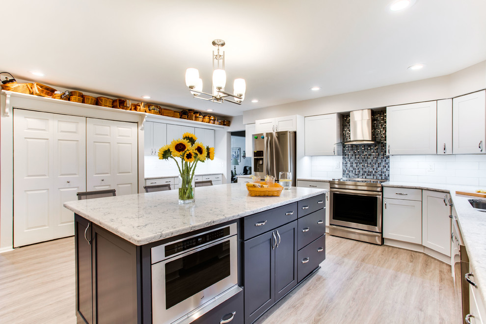 Mid-sized elegant kitchen photo in DC Metro with an undermount sink, shaker cabinets, quartz countertops, stainless steel appliances and an island