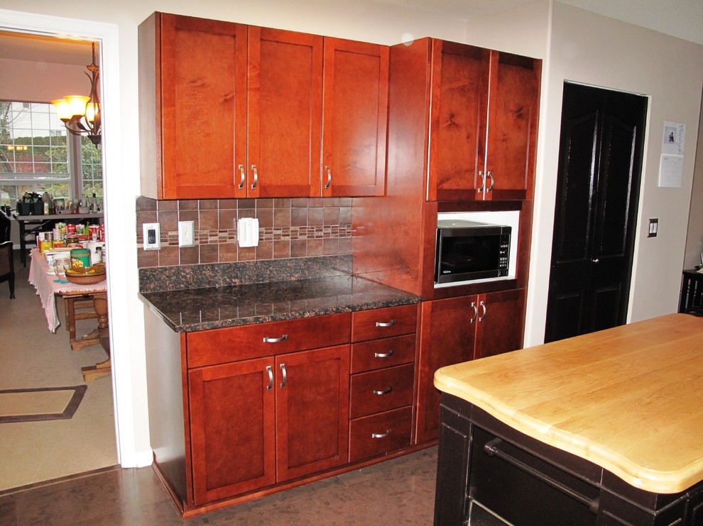 This is an example of a medium sized traditional u-shaped kitchen/diner in Seattle with medium wood cabinets.