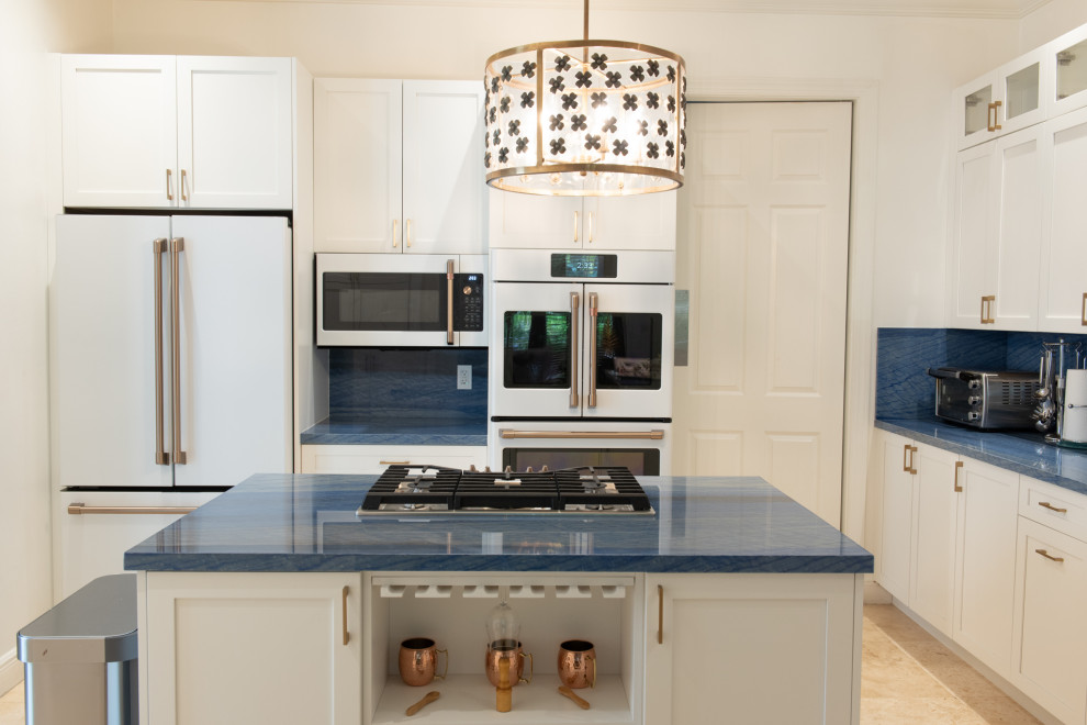 Стильный дизайн: п-образная кухня среднего размера в классическом стиле с обеденным столом, врезной мойкой, фасадами в стиле шейкер, белыми фасадами, синим фартуком, белой техникой, островом и синей столешницей - последний тренд