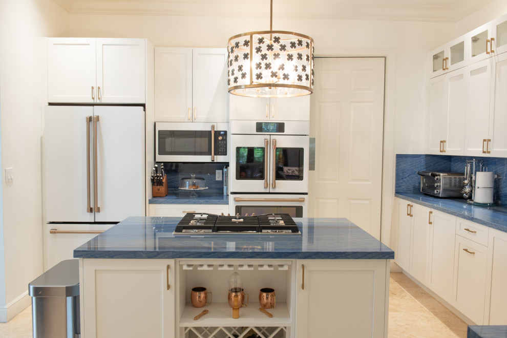 マイアミにある中くらいなトラディショナルスタイルのおしゃれなキッチン (アンダーカウンターシンク、シェーカースタイル扉のキャビネット、白いキャビネット、青いキッチンパネル、白い調理設備、青いキッチンカウンター) の写真