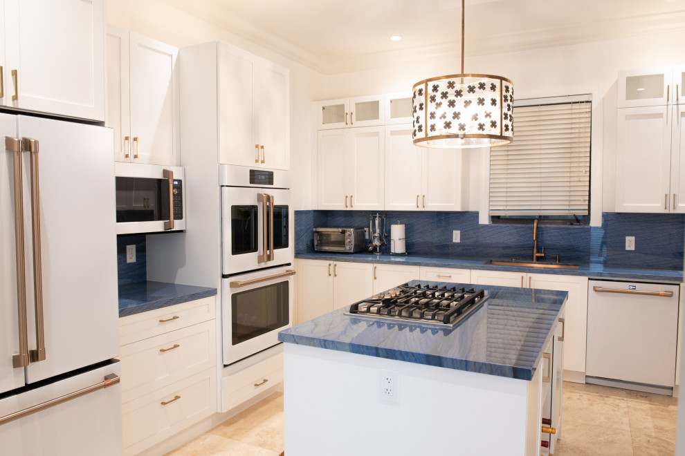 Design ideas for a medium sized classic u-shaped kitchen/diner in Miami with a submerged sink, shaker cabinets, white cabinets, blue splashback, white appliances, an island and blue worktops.