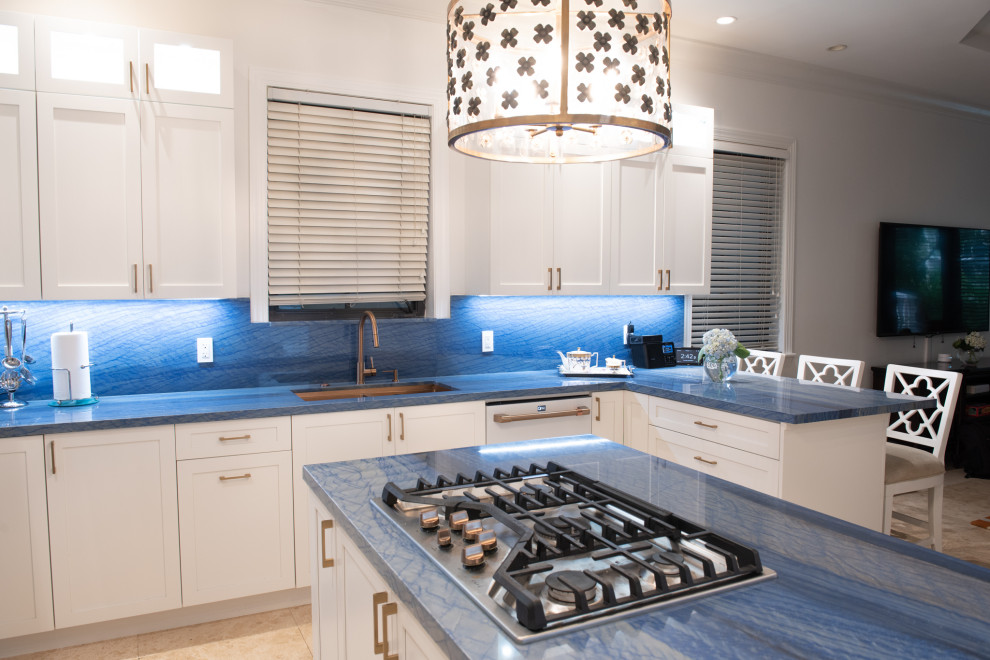 Foto på ett mellanstort vintage blå kök, med en undermonterad diskho, skåp i shakerstil, vita skåp, blått stänkskydd, vita vitvaror och en köksö