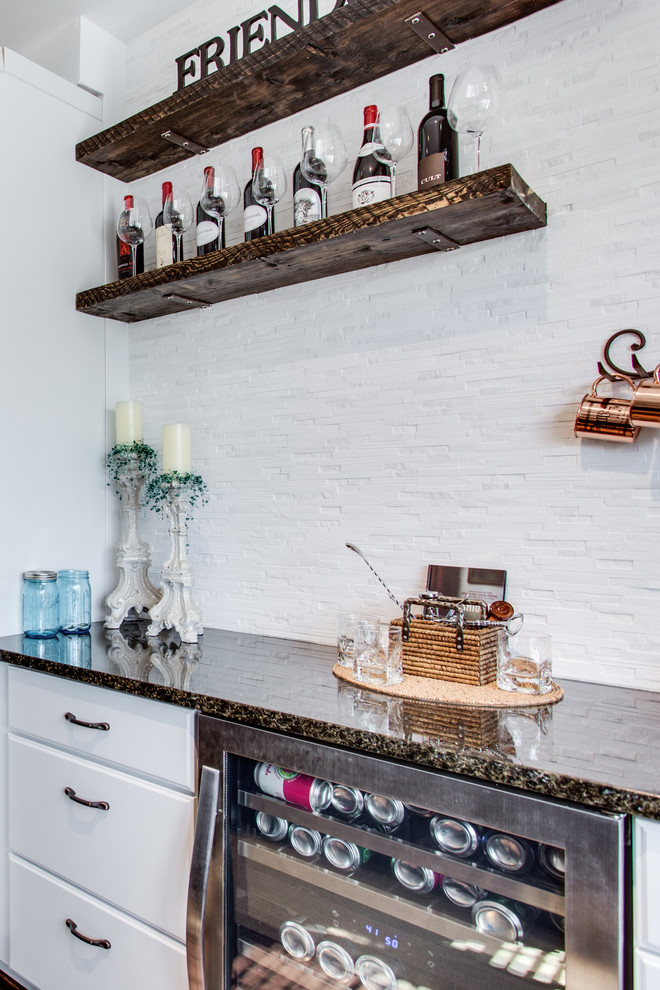 Imagen de bar en casa clásico con fregadero bajoencimera, armarios con paneles con relieve, encimera de granito y suelo de madera en tonos medios