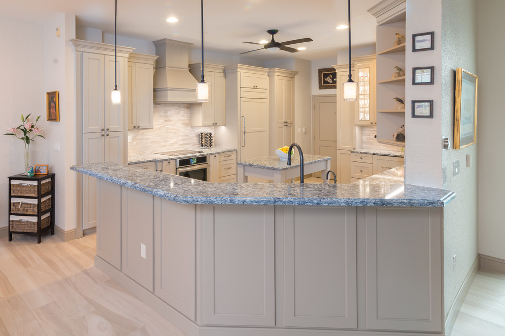 Example of a mid-sized classic porcelain tile and beige floor enclosed kitchen design in Miami with an undermount sink, shaker cabinets, beige cabinets, quartz countertops, multicolored backsplash, stone tile backsplash, paneled appliances and an island