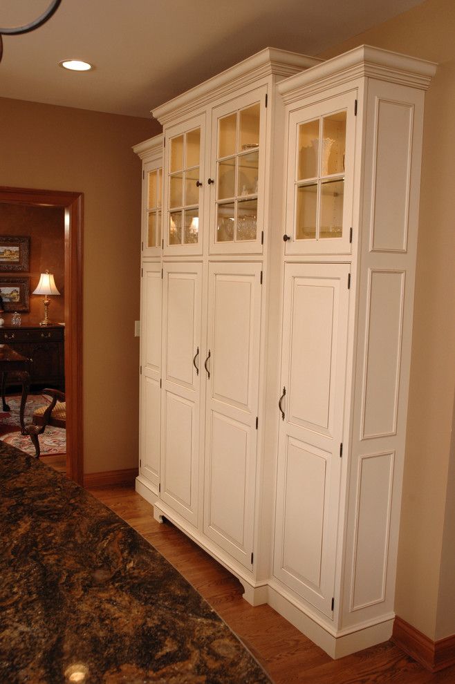 Aménagement d'une cuisine classique avec un placard avec porte à panneau surélevé et des portes de placard blanches.