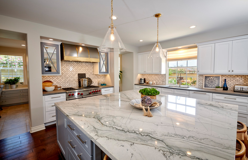 Inspiration for a large timeless u-shaped dark wood floor and brown floor open concept kitchen remodel in San Diego with an undermount sink, recessed-panel cabinets, white cabinets, quartzite countertops, gray backsplash, marble backsplash, stainless steel appliances, an island and white countertops