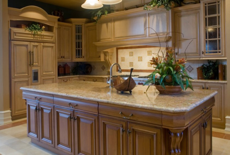 This is an example of a traditional l-shaped kitchen in Denver with a single-bowl sink, raised-panel cabinets, medium wood cabinets, granite worktops, beige splashback, ceramic splashback, integrated appliances, ceramic flooring, an island, beige floors and beige worktops.