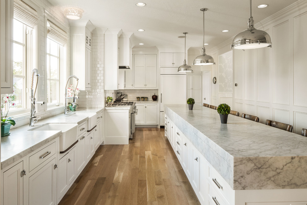Elegant kitchen photo in Salt Lake City with recessed-panel cabinets, white cabinets, white backsplash, subway tile backsplash and paneled appliances