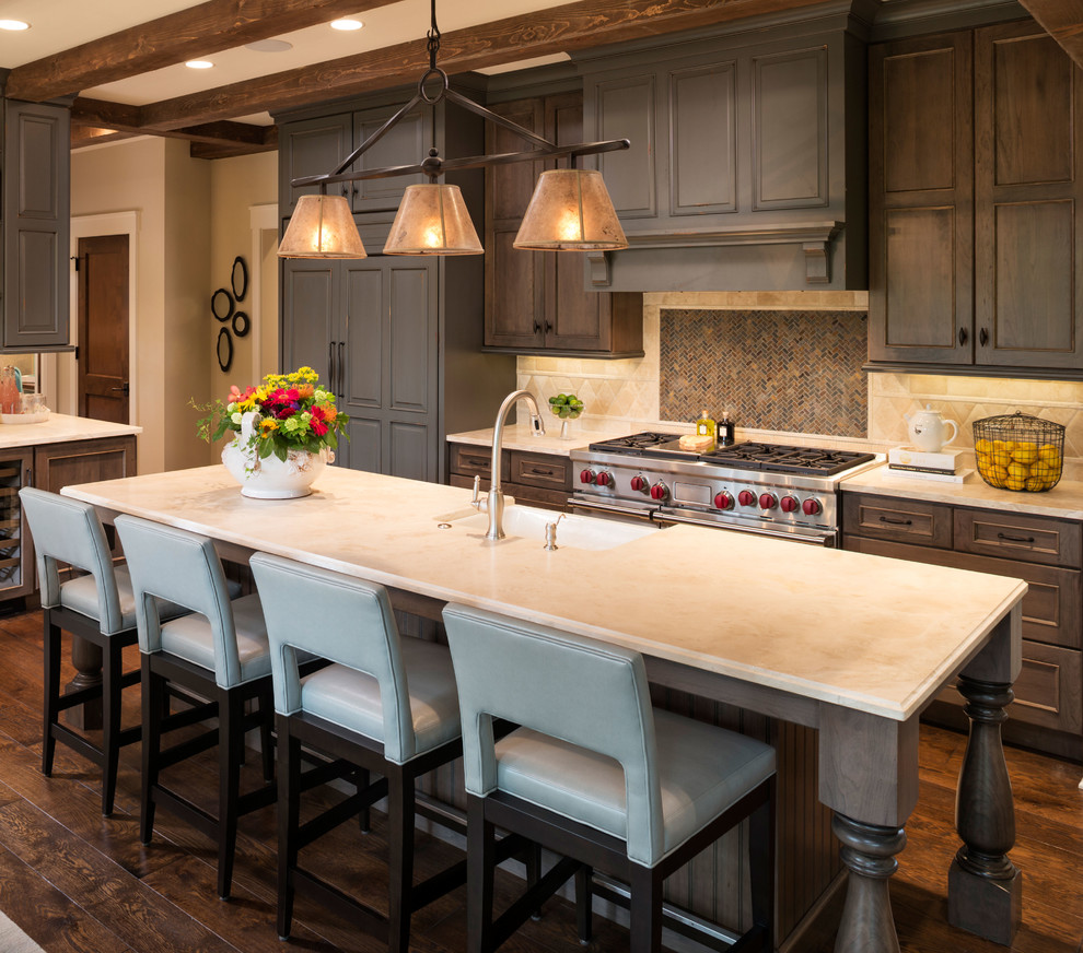 ミネアポリスにあるトラディショナルスタイルのおしゃれなアイランドキッチン (濃色木目調キャビネット、ベージュキッチンパネル、シルバーの調理設備、濃色無垢フローリング) の写真