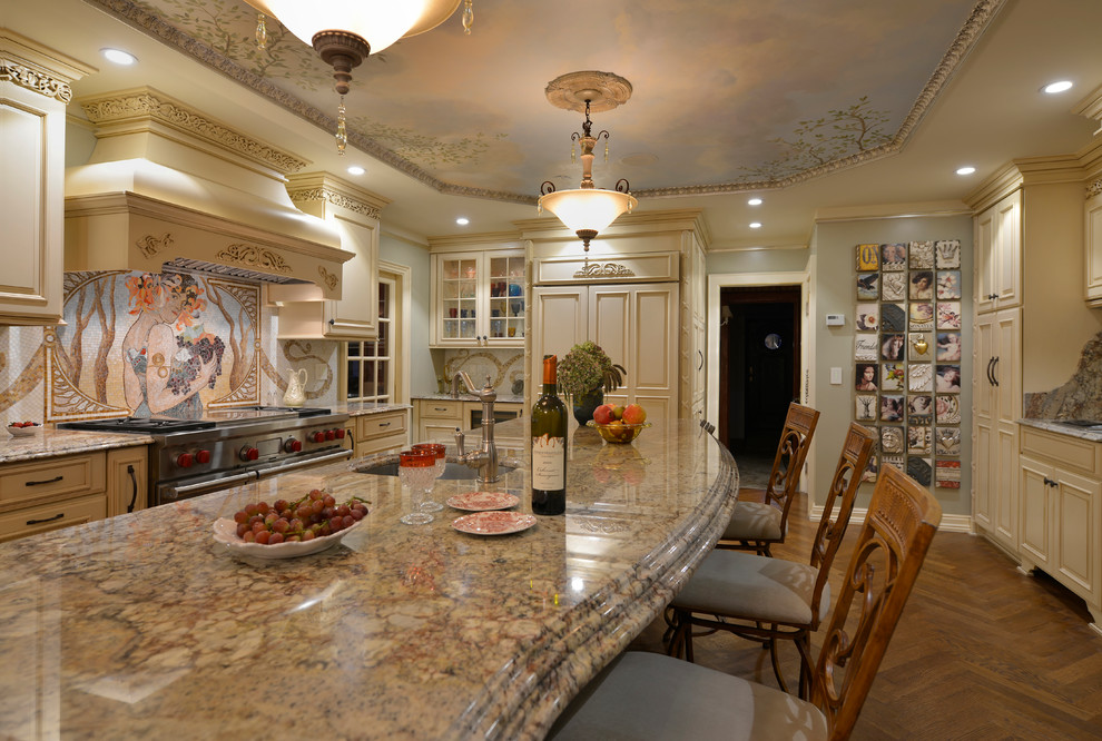 Klassisk inredning av ett stort kök, med granitbänkskiva, en rustik diskho, luckor med upphöjd panel, beige skåp, flerfärgad stänkskydd, stänkskydd i mosaik, rostfria vitvaror, ljust trägolv och en köksö
