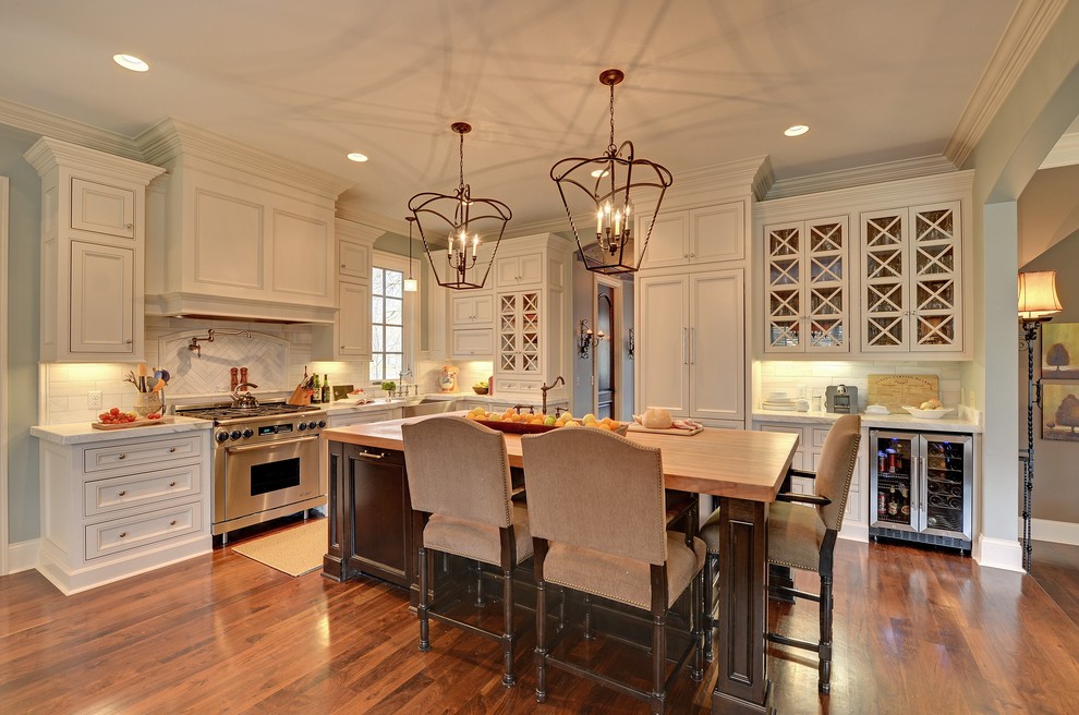 ミネアポリスにあるトラディショナルスタイルのおしゃれなL型キッチン (インセット扉のキャビネット、パネルと同色の調理設備、白いキャビネット、白いキッチンパネル) の写真