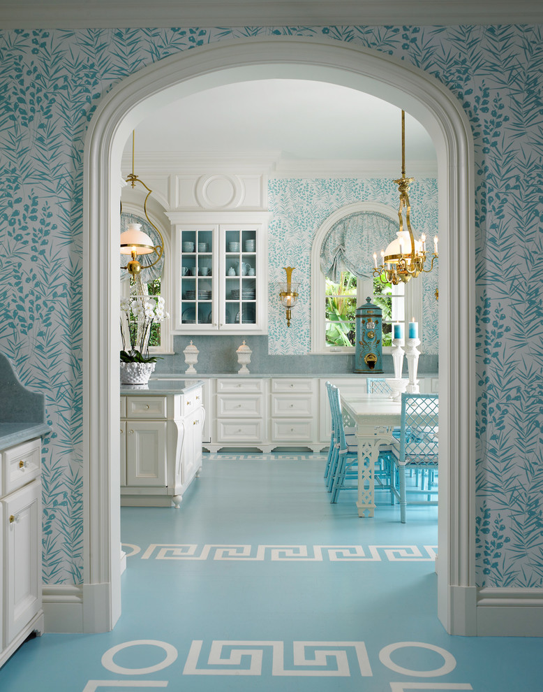 Idée de décoration pour une cuisine américaine tradition avec un placard avec porte à panneau encastré, des portes de placard blanches, une crédence bleue et papier peint.
