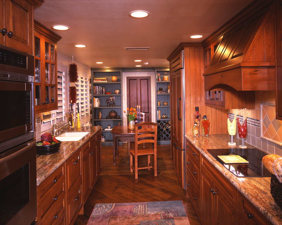 サンディエゴにあるトラディショナルスタイルのおしゃれなII型キッチン (パネルと同色の調理設備、御影石カウンター) の写真