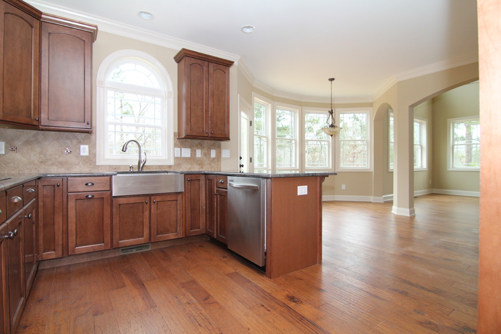 Example of a mid-sized classic l-shaped medium tone wood floor open concept kitchen design in Raleigh with a single-bowl sink, recessed-panel cabinets, medium tone wood cabinets, granite countertops, beige backsplash, ceramic backsplash, stainless steel appliances and a peninsula