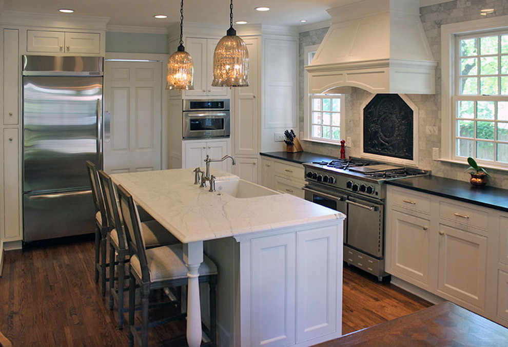 Inspiration for a large timeless l-shaped medium tone wood floor eat-in kitchen remodel in Other with an island, beaded inset cabinets, white cabinets, marble countertops, white backsplash, stone tile backsplash, stainless steel appliances and a farmhouse sink