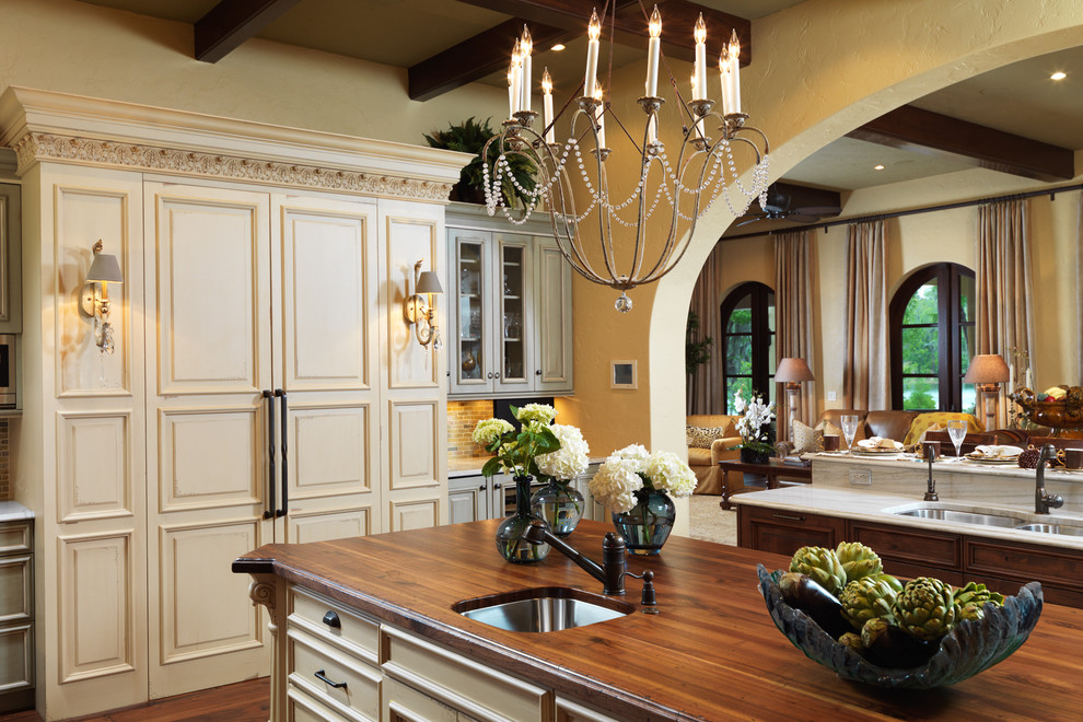 Kitchen - traditional kitchen idea in Tampa with wood countertops, raised-panel cabinets and beige cabinets