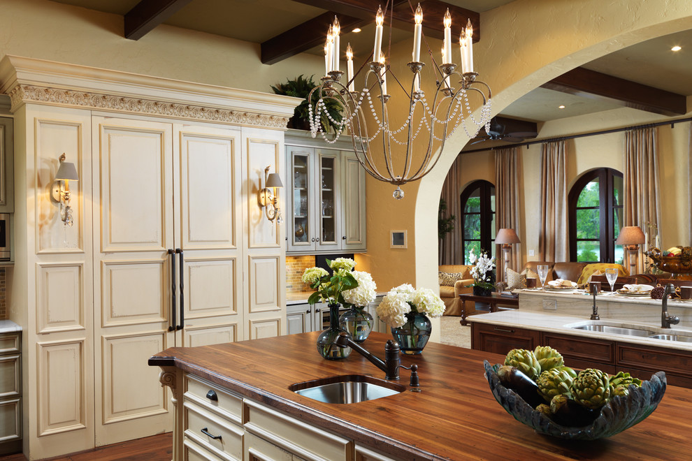 Imagen de cocina clásica con encimera de madera, armarios con paneles con relieve y puertas de armario beige