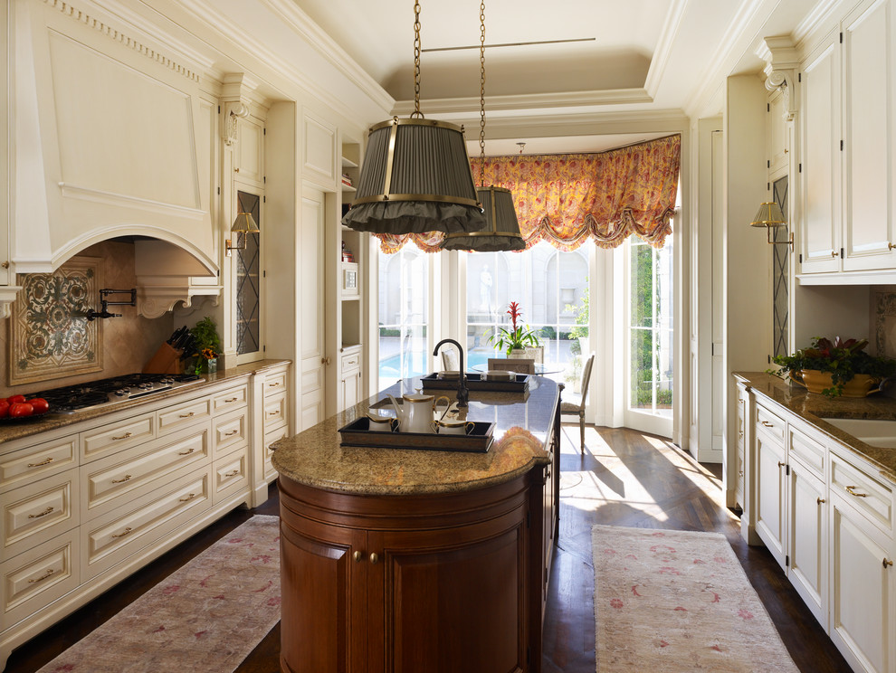 Example of a classic eat-in kitchen design in New Orleans with an undermount sink, raised-panel cabinets, beige cabinets and beige backsplash