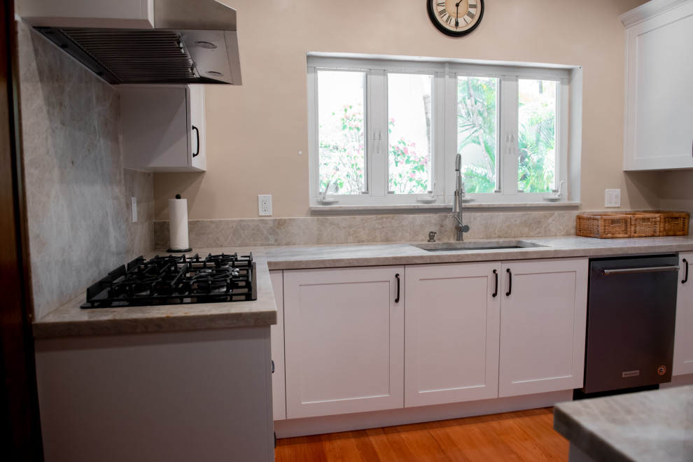 Cette image montre une petite arrière-cuisine parallèle traditionnelle avec des portes de placard blanches.