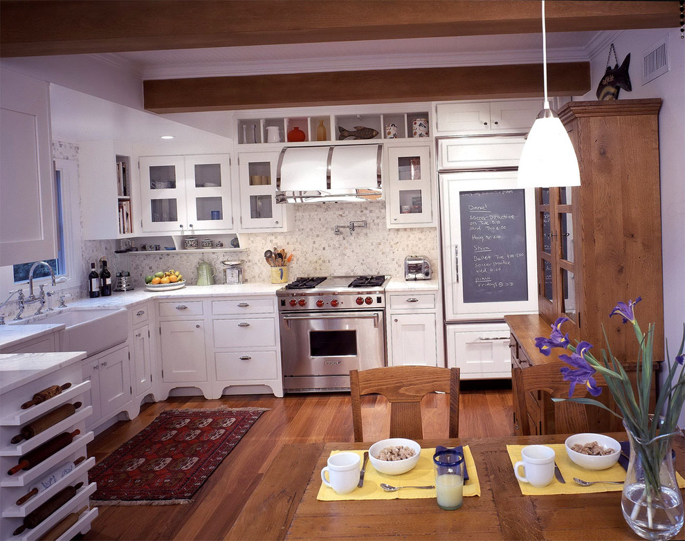 Cette image montre une cuisine encastrable traditionnelle en U avec un évier de ferme, des portes de placard blanches, une crédence blanche et une crédence en carrelage de pierre.