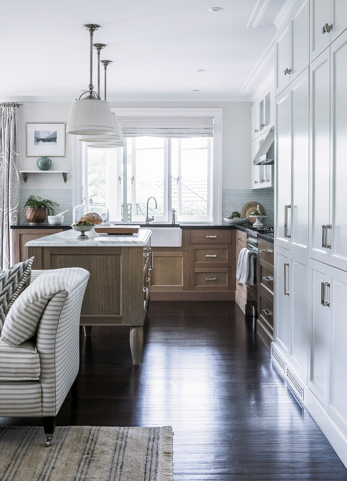 Inspiration for a timeless l-shaped dark wood floor kitchen remodel in Sydney with a farmhouse sink, recessed-panel cabinets, marble countertops, stainless steel appliances, an island, medium tone wood cabinets, blue backsplash and glass tile backsplash