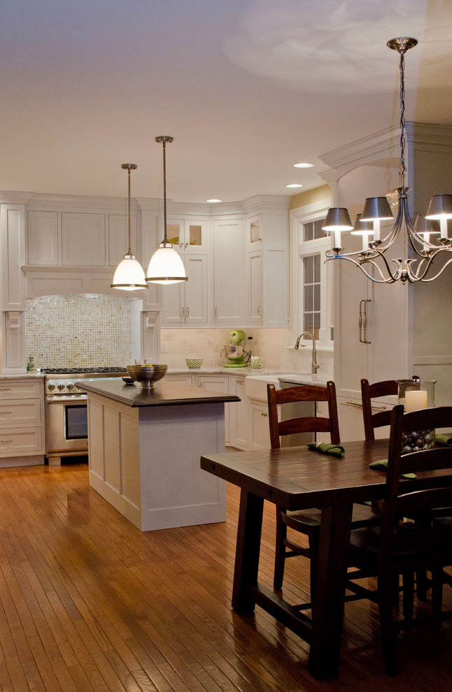Eat-in kitchen - large traditional u-shaped light wood floor eat-in kitchen idea in Philadelphia with a single-bowl sink, shaker cabinets, yellow cabinets, wood countertops, white backsplash, subway tile backsplash, paneled appliances and an island