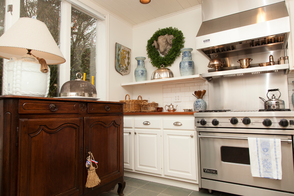 Diseño de cocina clásica con salpicadero de azulejos tipo metro y encimera de madera