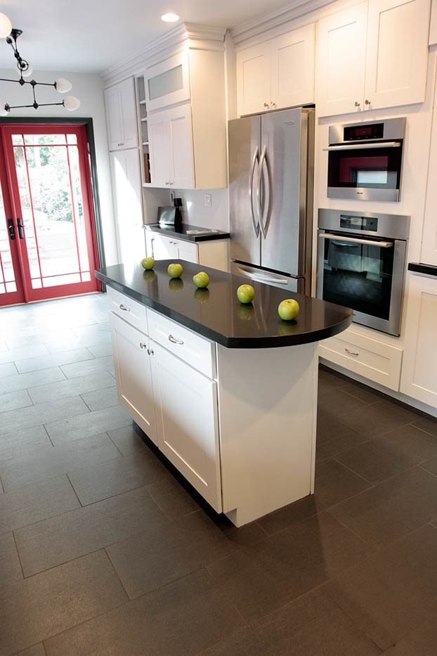 Medium sized traditional u-shaped enclosed kitchen in San Francisco with a single-bowl sink, shaker cabinets, white cabinets, engineered stone countertops, black splashback, stainless steel appliances, porcelain flooring and an island.