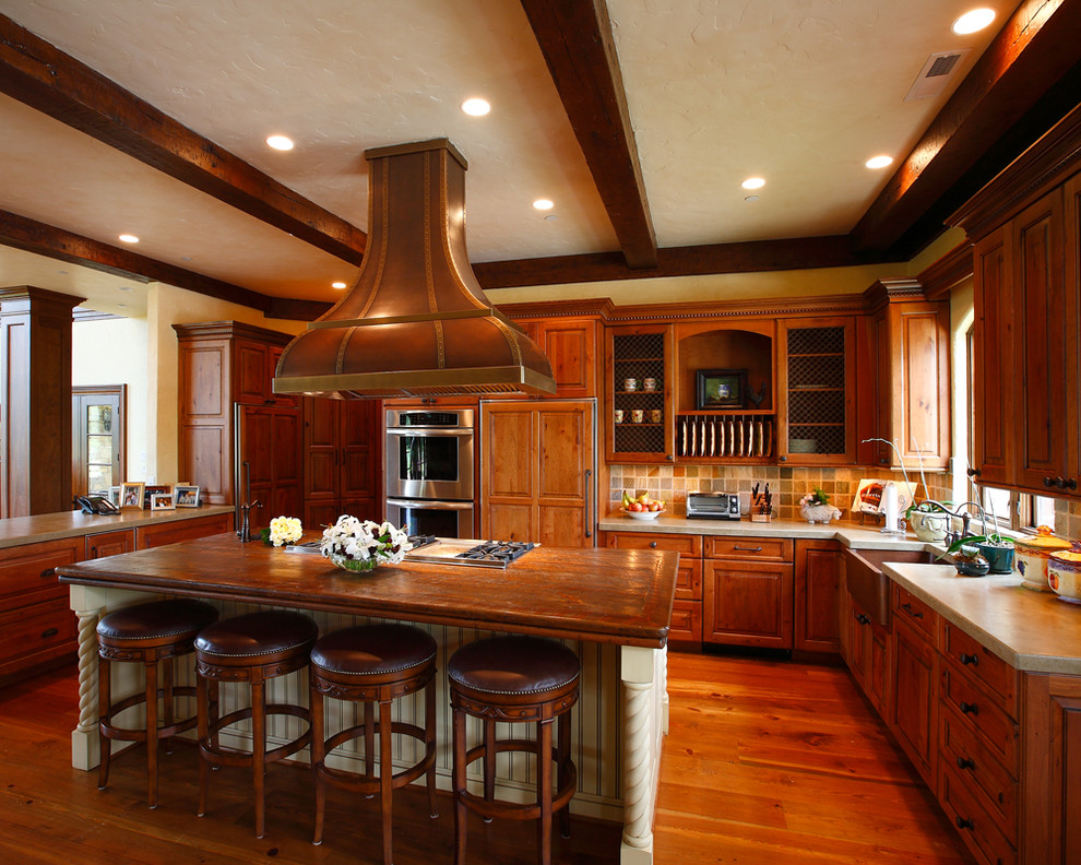 Exempel på ett stort klassiskt kök, med en rustik diskho, luckor med upphöjd panel, skåp i mellenmörkt trä, flerfärgad stänkskydd, integrerade vitvaror, träbänkskiva, mellanmörkt trägolv och en köksö