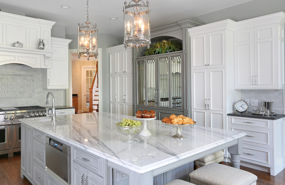 Exempel på ett stort klassiskt kök, med en undermonterad diskho, vita skåp, granitbänkskiva, grått stänkskydd, stänkskydd i stenkakel, rostfria vitvaror, mörkt trägolv, en köksö och luckor med infälld panel